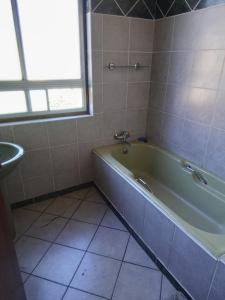a bathroom with a green tub and a sink at Vryburg Good Time Yafe Guest House in Vosburg