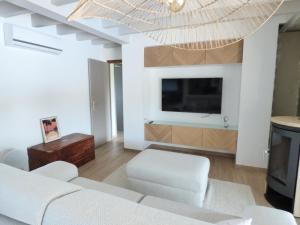 梅桑热Villa LANDAYA Cozy & Calme avec piscine privée的客厅里有一张沙发和一台电视