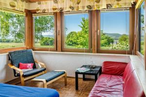 un salon avec un canapé, des chaises et des fenêtres dans l'établissement Ferienwohnung Landleben, à Hofgeismar