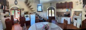a large kitchen with white cabinets and a table at Moulin de la Licorne in Saint-Savinien