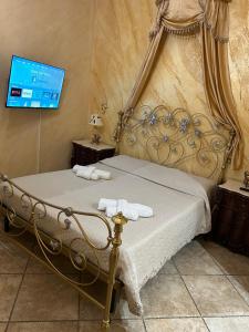 a bedroom with a bed and a tv on a wall at Barocco House in Catania