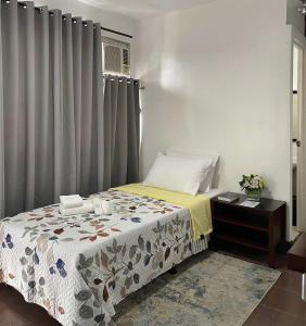 a bedroom with a bed and a window with curtains at Miran Hotel in Legazpi