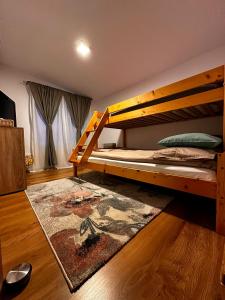 a bedroom with two bunk beds and a rug at Wanderlust Cottage Avrig in Avrig