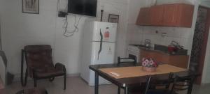 a kitchen with a table and a white refrigerator at la flor del lugar in Potrerillos