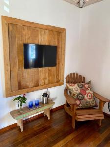 a living room with a couch and a television on a wall at Cantinho Almeida in Tiradentes