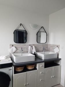 a bathroom with two sinks and two mirrors at Odyssée-Le Nautile in Béthisy-Saint-Pierre