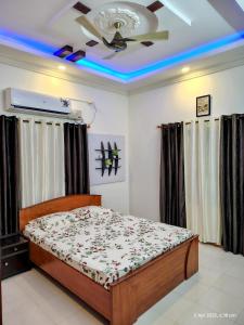 a bedroom with a bed and a ceiling fan at Kinaara Homestay Thottam Malpe Beach Udupi in Malpe