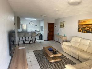 a living room with a couch and a table at Laguna La Crete 91, Uvongo in Uvongo Beach