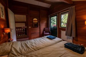 Un dormitorio con una cama en una habitación con ventana. en Vacation Home North Limburg, en Blitterswijck