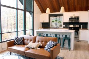 a living room with a couch and a kitchen at Cozy Cottage 1 Block Walk From Lake Naomi - Poconos Pennsylvania Area 2 hours from New York City or Philadelphia - Pets Welcome - Check Minimum Night Requirement in Pocono Pines