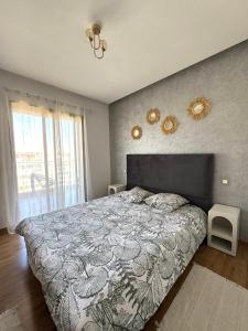 een slaapkamer met een bed en een groot raam bij The pearl garden vu piscine in Marrakesh