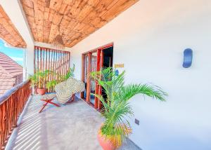 a porch with potted plants on a balcony at Ananda Beach Hotel in Paje