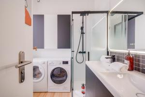 une petite salle de bains avec un lave-linge et un lavabo dans l'établissement La Socket - maison près du centre-ville, à Le Bouscat