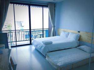 a bedroom with a large bed with a balcony at Rinrada Loft Resident in Chiang Mai