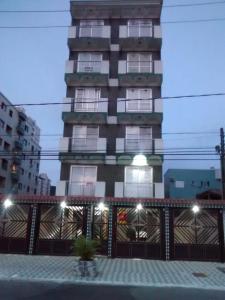 um edifício alto com uma planta em frente em Apartamento Boqueirao na Praia Grande