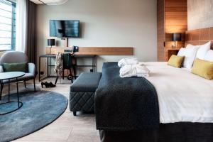 a hotel room with a bed and a chair and a table at Scandic Simonkenttä in Helsinki