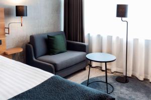 a hotel room with a chair and a bed at Scandic Simonkenttä in Helsinki