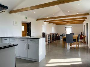 a kitchen with white cabinets and a dining room at Quinta do Almanac in Queimada