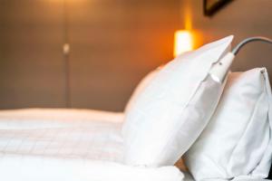 a bed with white pillows on top of it at Scandic Simonkenttä in Helsinki