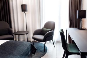 a hotel room with chairs and a bed and a table at Scandic Simonkenttä in Helsinki