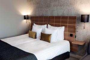 a bedroom with a large bed with two pillows at Scandic Simonkenttä in Helsinki
