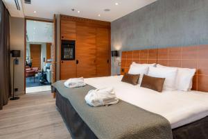 a bedroom with a large bed with two towels on it at Scandic Simonkenttä in Helsinki