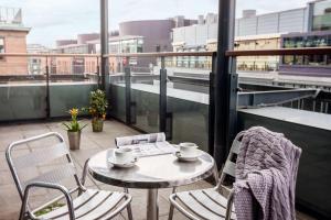 a table and chairs on a balcony with a view of a city at Scandic Simonkenttä in Helsinki