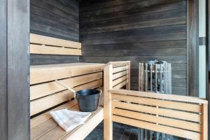 a sauna with wood paneling and a bucket at Scandic Simonkenttä in Helsinki
