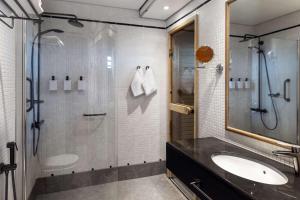 a bathroom with a glass shower and a sink at Scandic Simonkenttä in Helsinki