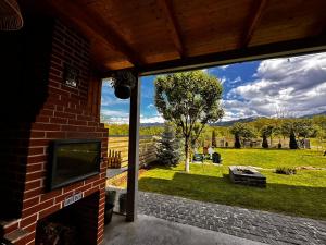 a view of a yard from a house with a tv at Wanderlust Cottage Avrig in Avrig