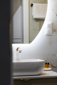 un bagno con un lavandino bianco e uno specchio di Amber Elegance Stegna w Apartamentach Bursztynowych a Stegna Altre 13 foto