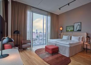 una camera da letto con un letto grande e una grande finestra di Scandic Göteborg Central a Göteborg