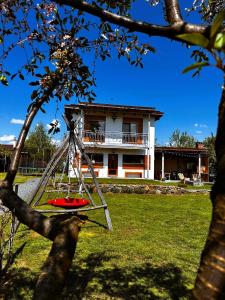 a toy swing in front of a building at Wanderlust Cottage Avrig in Avrig