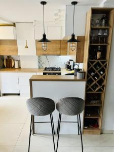 a kitchen with two bar stools at a counter at Sarajevo Stories Apartments Free Parking in Sarajevo +43 photos
