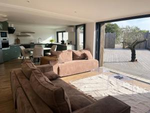 a living room with two couches and a glass table at Cyprès de l'Océan in Angles