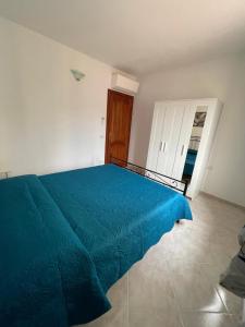 a bedroom with a blue bed in a room at Appartamento Gallospot in San Teodoro
