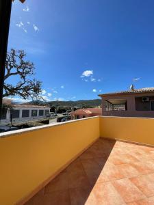 a yellow fence on a balcony of a house at Appartamento Gallospot in San Teodoro