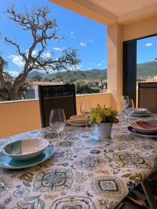 a table with plates and wine glasses on a patio at Appartamento Gallospot in San Teodoro