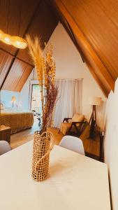 a room with a table with a vase with flowers on it at Cabana Pitomba - Viagem Inspirada in Fernando de Noronha