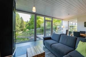 a living room with a blue couch and a large window at 2 bis 4 Personen F1H3 in Ruhla