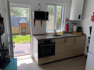 una cocina con fregadero y estufa horno superior en Vila Alegre, en Fuseta 9 fotos más