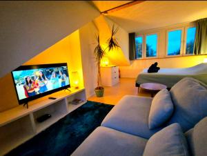 a living room with a couch and a television at Welkom op Texel privé studio in De Koog