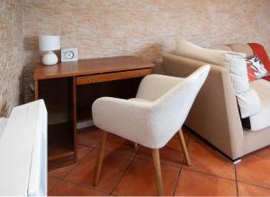 a desk and a chair next to a couch at AG Piso Caldeirón Malpica, primera linea de playa in Malpica