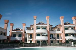 an apartment building with a pool in front of it at Casa Origine, appartamento vista piscina, al mare in Cavallino-Treporti