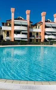 a swimming pool in front of a building at Casa Origine, appartamento vista piscina, al mare in Cavallino-Treporti