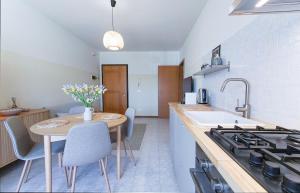 a kitchen with a table and a stove top oven at Casa Origine, appartamento vista piscina, al mare in Cavallino-Treporti
