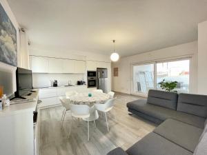 a kitchen and living room with a table and chairs at IDA PALACE, nuovo appartamento deluxe fronte mare in Stintino +21 photos