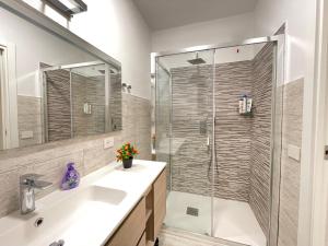 a bathroom with a shower with a sink and a glass door at IDA PALACE, nuovo appartamento deluxe fronte mare in Stintino