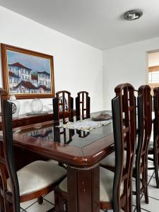 ein Esszimmer mit einem Holztisch und Stühlen in der Unterkunft Casa agradável e muito ampla em Campina Grande in Campina Grande