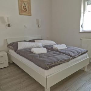 a large bed with two towels on top of it at Vila Natasa Apartment 2 near Plitvice in Vrhovine